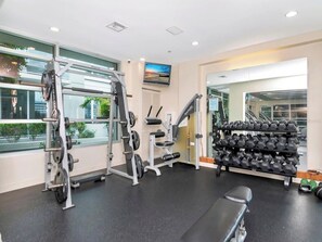A gym with weightlifting equipment, a bench, and a rack of dumbbells. - Luxury 2BR/2BA Tampa Channelside Downtown - Gym + Sauna + Pool  (Tampa)