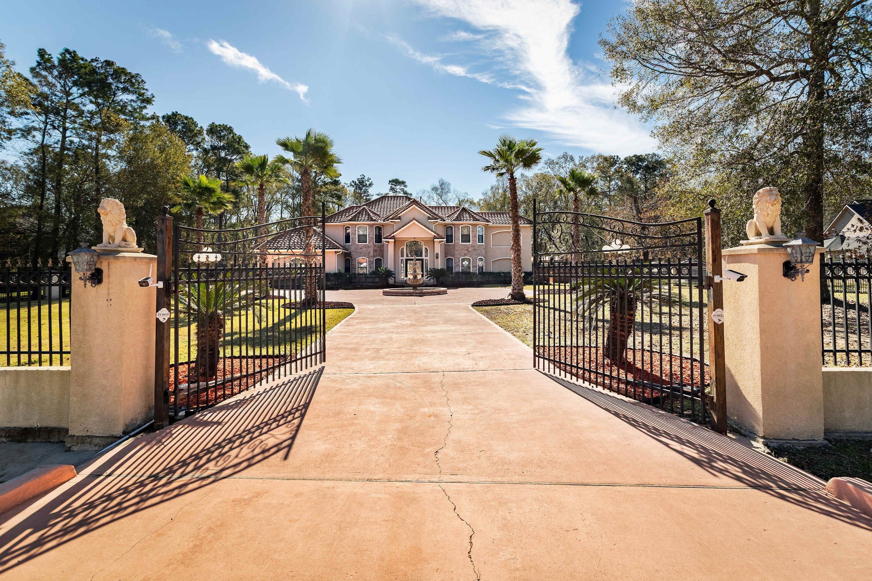 A gated entrance to a property with a central pathway leading to a building.