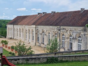 A historic building with a tiled roof and arched windows. - Group Home in Burgundy: L'antre amis (Molesme)