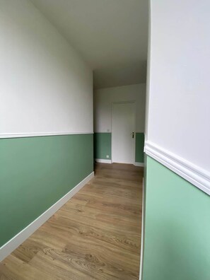 A hallway with green and white walls and wooden flooring. - Group Home in Burgundy: L'antre amis (Molesme)