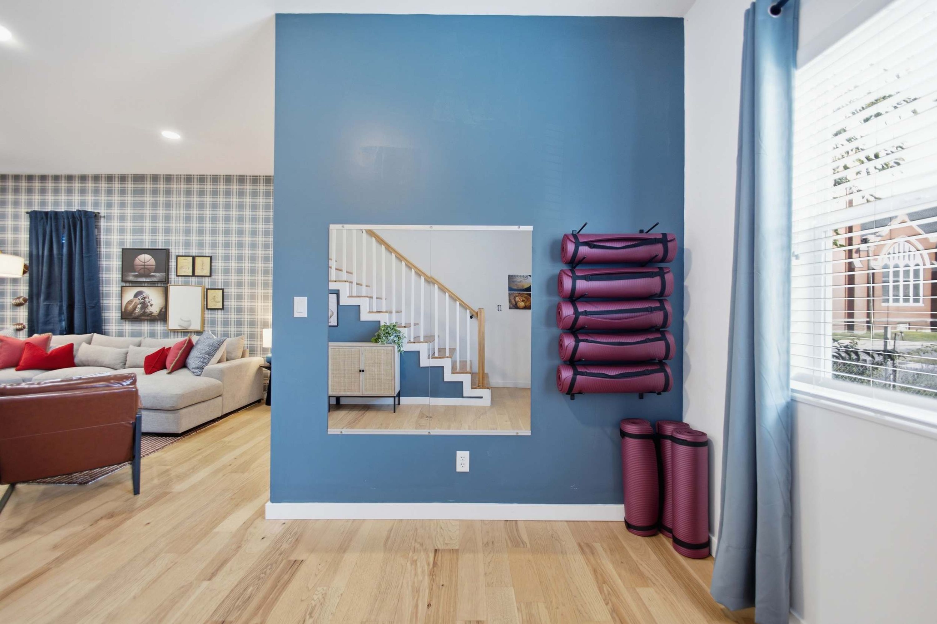 A living room with a sofa, a coffee table, and a TV. There is a staircase leading to an upper floor.