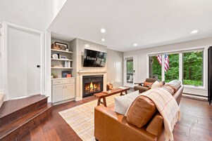 Una sala de estar con chimenea, televisor y sofá.