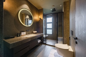 Une salle de bain moderne avec un grand miroir, un lavabo et des toilettes.