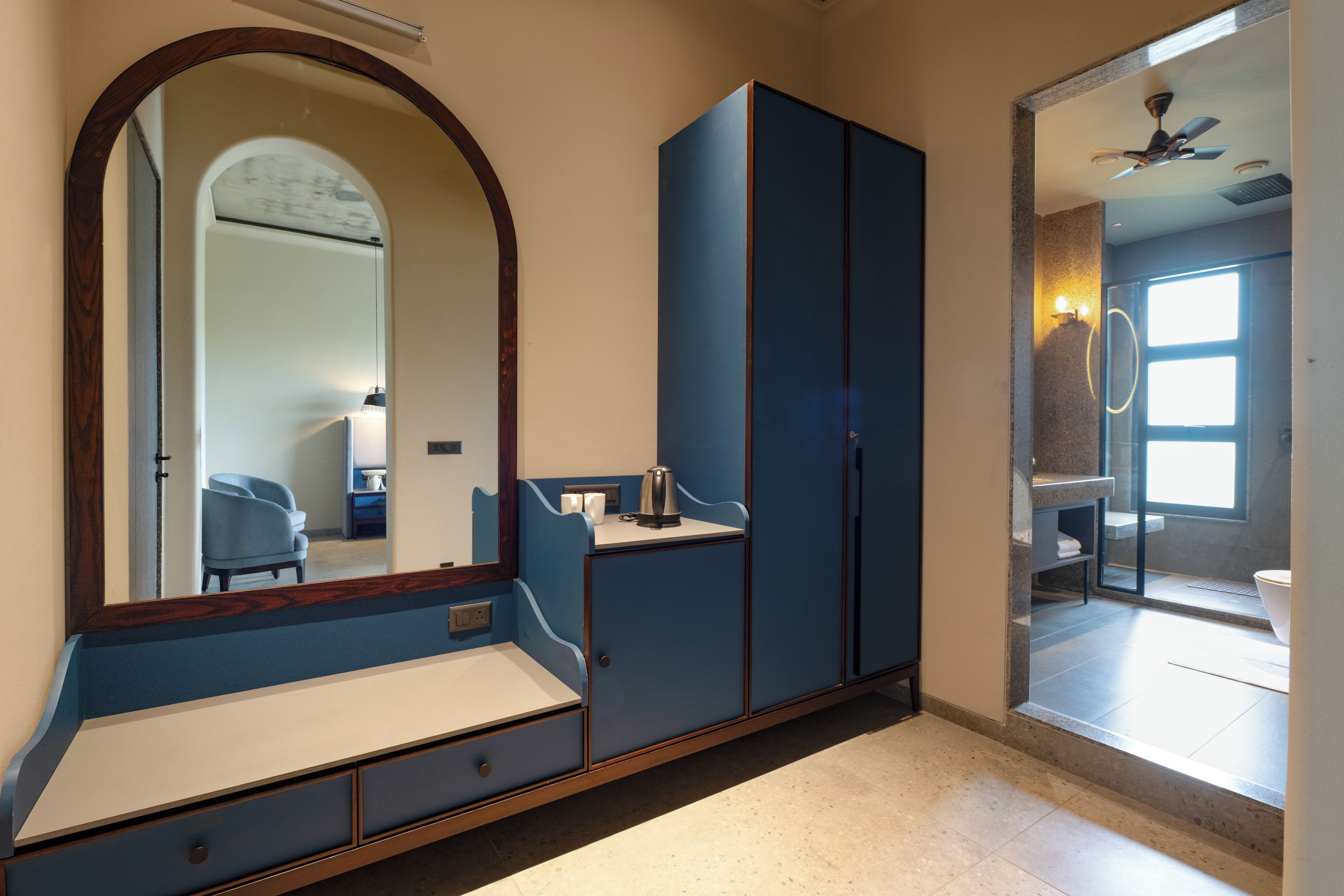 Une chambre avec un grand miroir, une armoire, une table de chevet et une vue sur la salle de bain.
