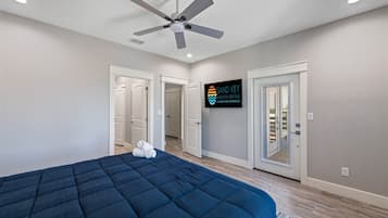 Un dormitorio con cama, ventilador de techo y un cartel de Sand Key Vacation Rentals.