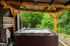 A hot tub under a wooden pergola with a view of a forested area. - Rolling Hills Retreat Hot Tub Fire Pit Sauna (Sevierville)