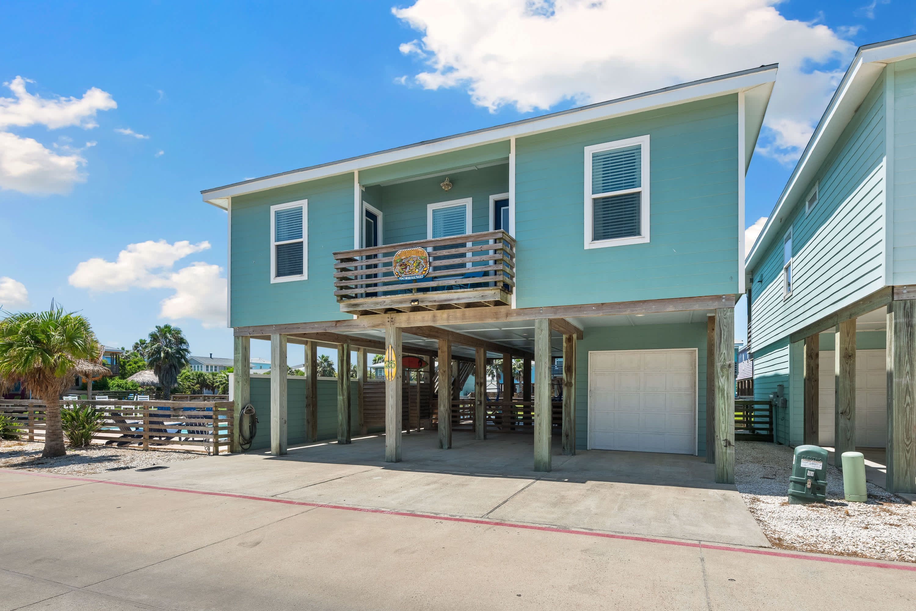 A two-story building with a balcony, a covered entrance, and a garage.