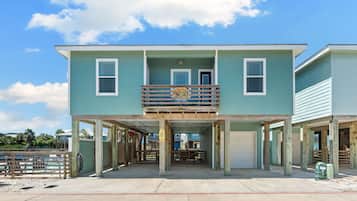 A two-story building with a balcony, a covered area, and a garage.