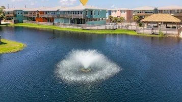 A waterfront property with a central water feature, a pool area, and a row of colorful buildings.