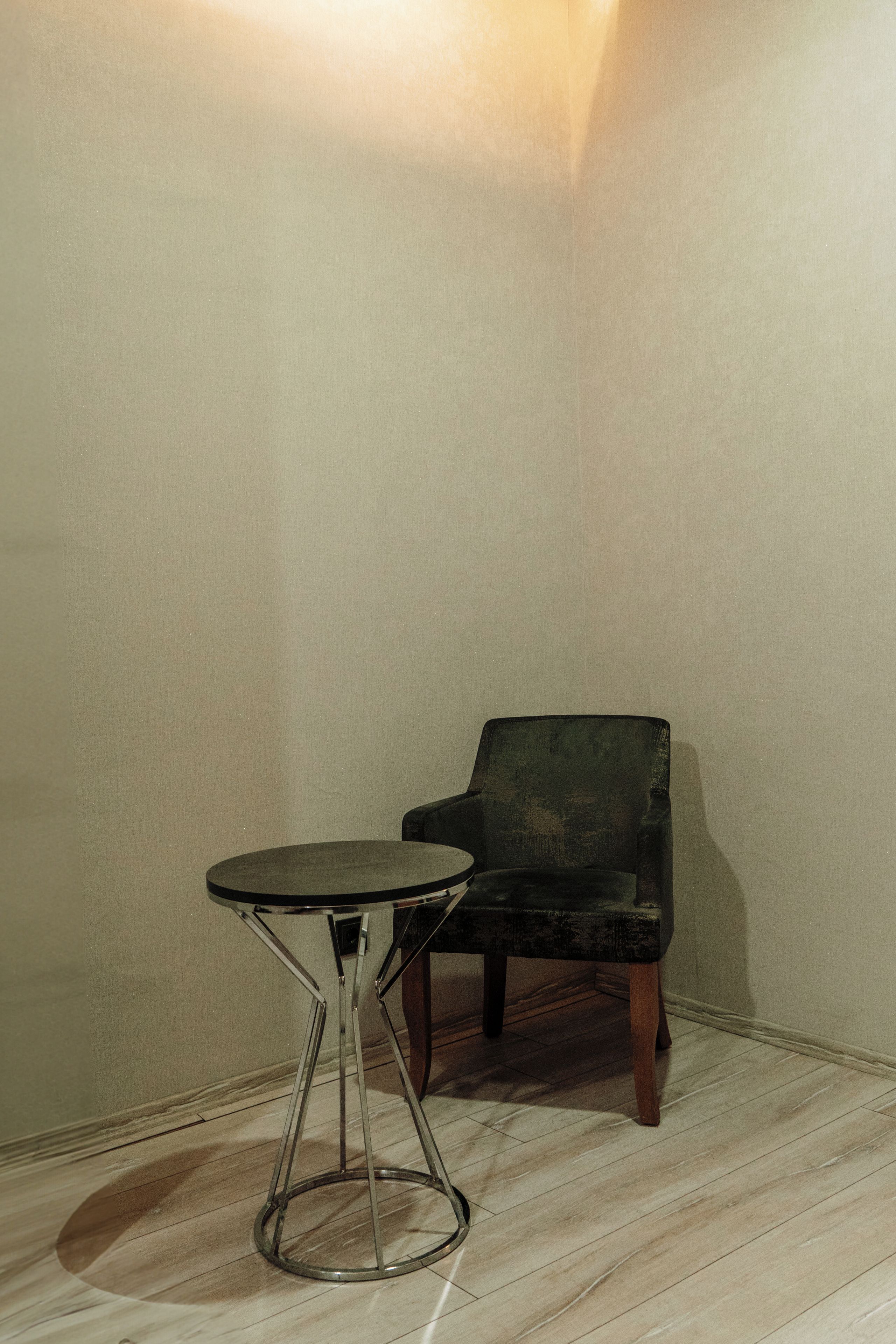 A corner room with a round table and a chair.