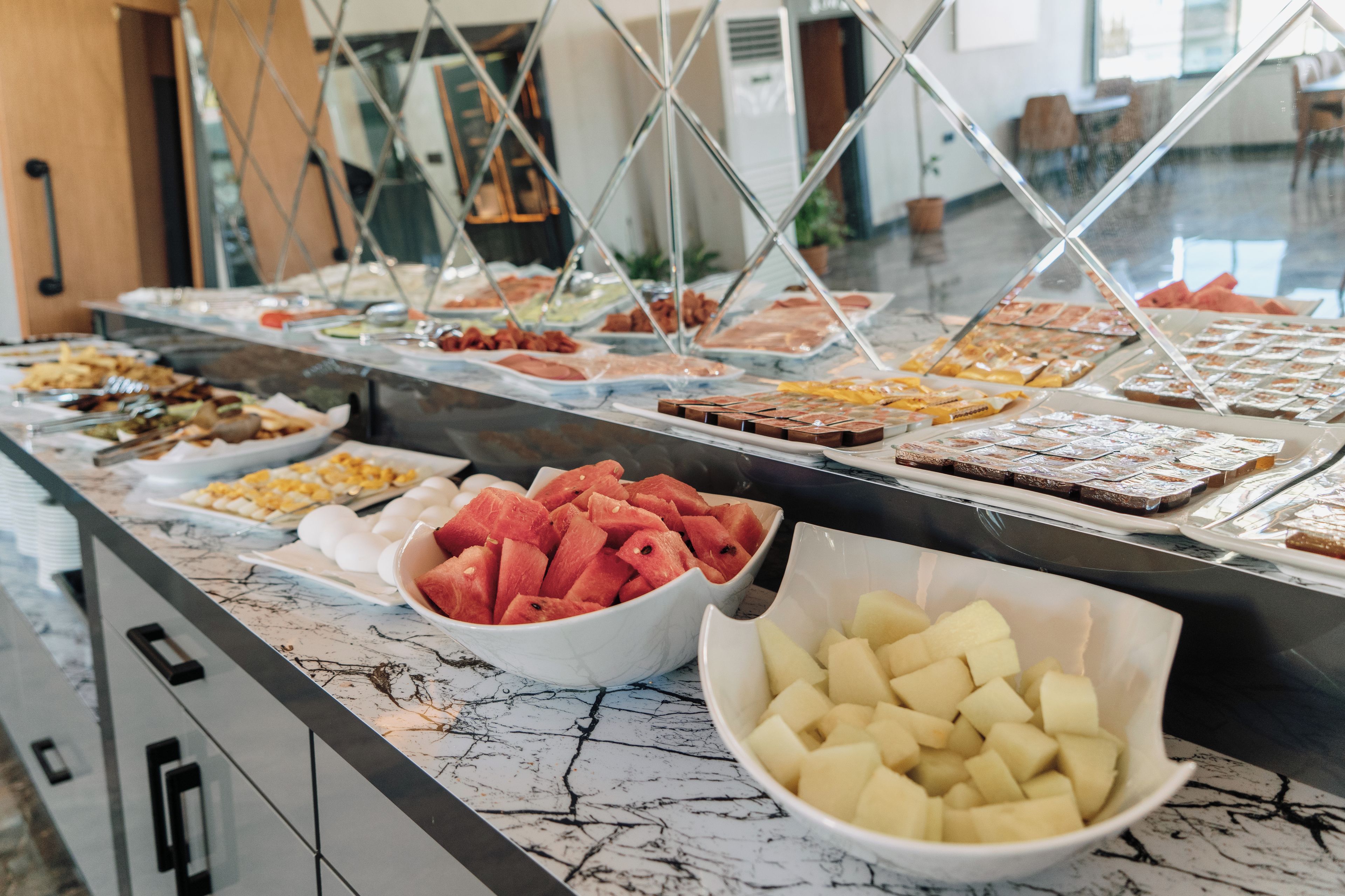 Un buffet con diverse portate, tra cui frutta e dolci.