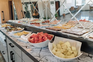 En buffet med et udvalg af mad, blandt andet frugt og desserter.