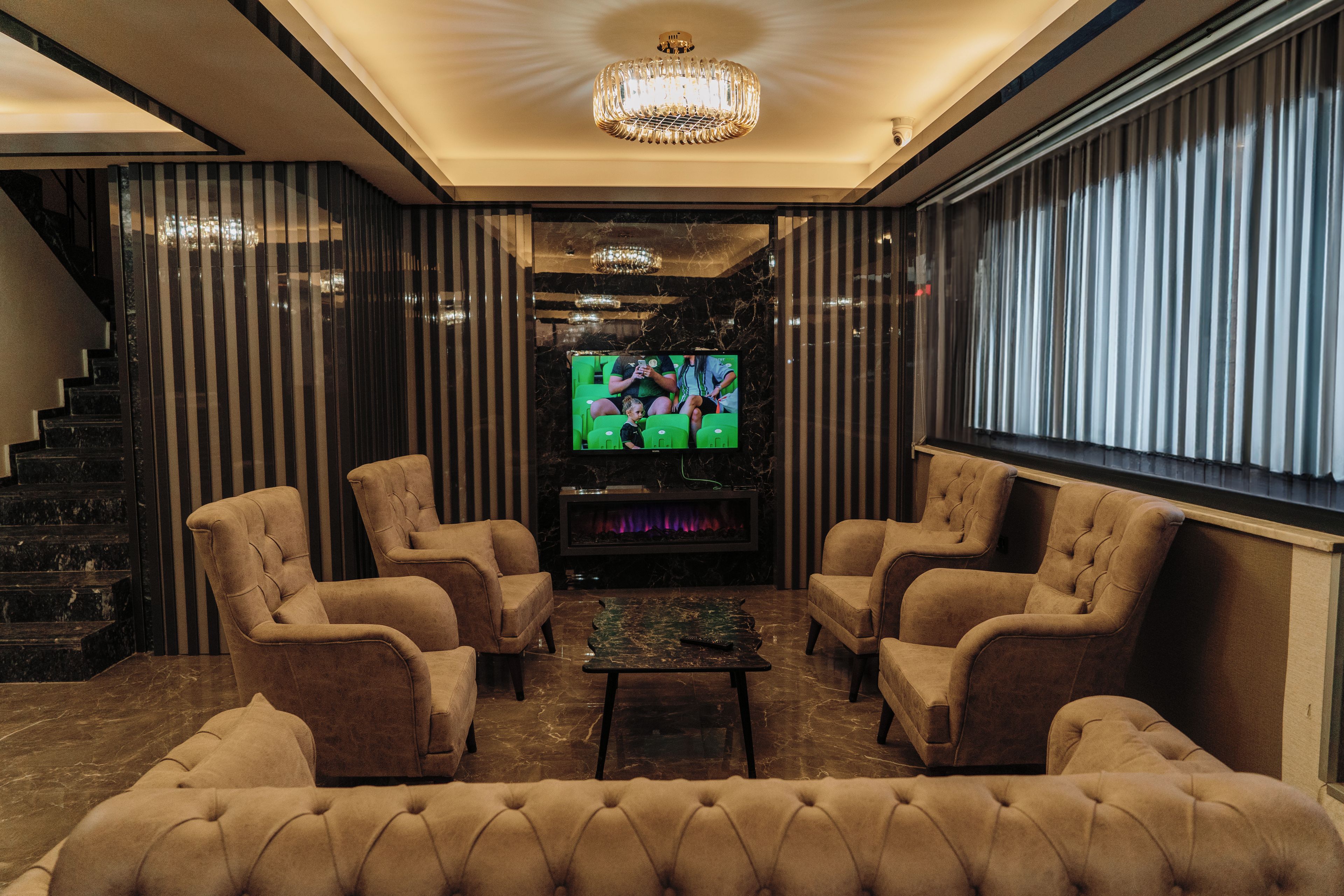 A modern living room with a fireplace, comfortable seating, and a television.