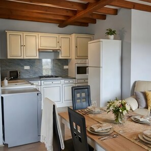 Une cuisine moderne avec des meubles blancs, une cuisinière et un réfrigérateur.