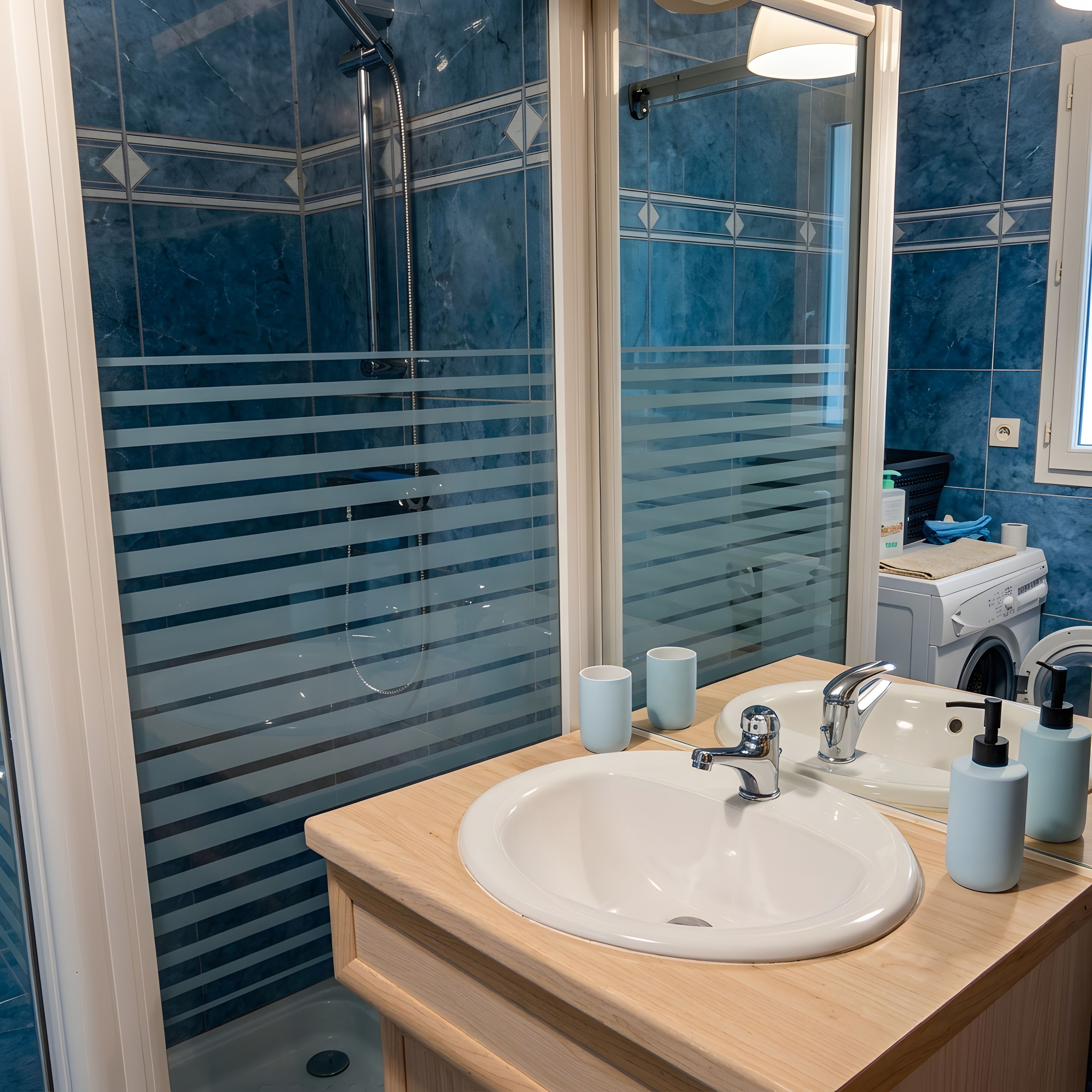 Een badkamer met een douchecabine van glas, een wit wastafelmeubel en een spiegel.
