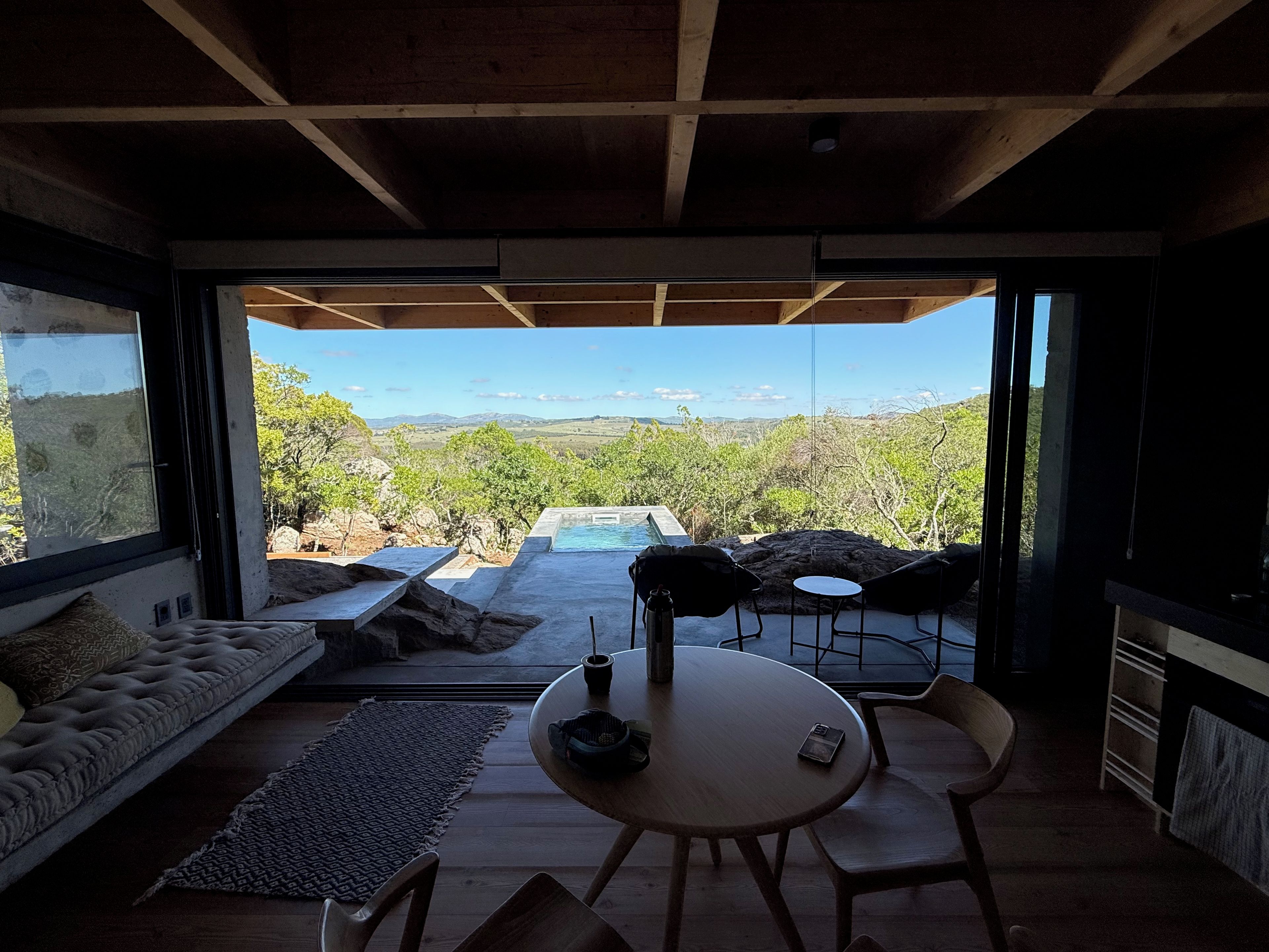 A modern interior with a view of a pool and landscape.