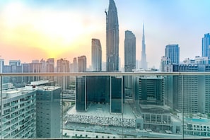 A high-rise building with multiple floors, large windows, and a modern architectural design. - HAVN - High Floor 1 Bed in Business Bay (Dubai)