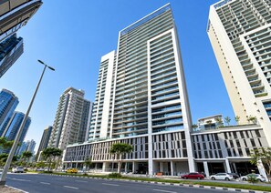 A modern high-rise building with multiple floors, large windows, and a prominent entrance. - HAVN - High Floor 1 Bed in Business Bay (Dubai)