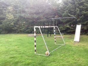 A soccer goal with a net, a small ball, and a slide to the right. - 8 Person Holiday Home in Vaeggerlose (Vaeggerlose)