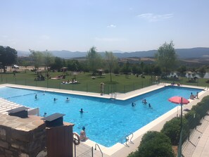 Ein Schwimmbad mit Blick auf einen See und Berge im Hintergrund.