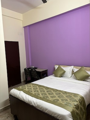 Un dormitorio con una cama, un escritorio y una silla.