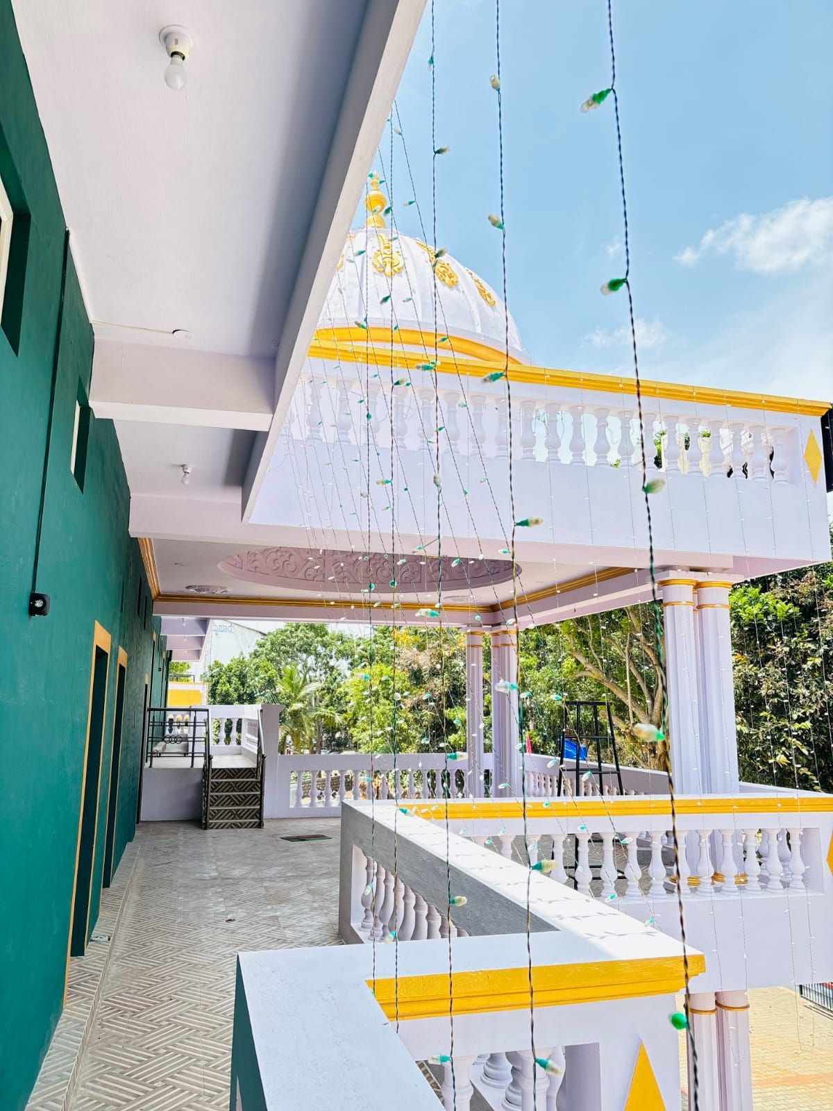 A covered outdoor area with a white and yellow structure, a white dome, and hanging decorations.