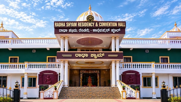 Un bâtiment sur lequel on peut lire l’inscription « Résidence Radha Shyam et salle de congrès », et un escalier menant à l’entrée.