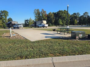A parking area with a picnic table and a utility box.