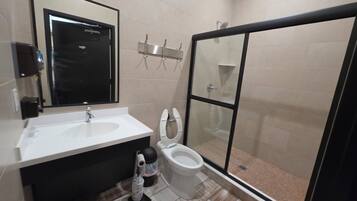 Ein Badezimmer mit Waschbecken, Toilette und einer Duschkabine.