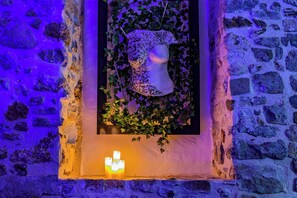 A stone wall with a rectangular alcove containing a white bust sculpture surrounded by ivy. - "Le Secret" Suite - Luxury & Private Jacuzzi (Lorgues)