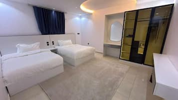 Une chambre d’hôtel moderne avec deux lits, un grand miroir et un placard à portes coulissantes.