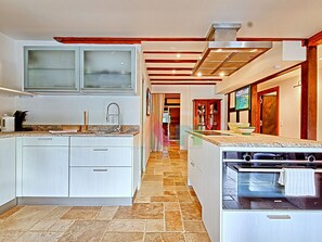 Eine moderne Küche mit weißen Schränken, einem eingebauten Backofen und einer Arbeitsplatte aus Granit.
