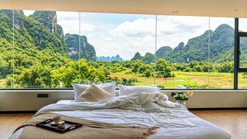 Une chambre dotée d’une grande fenêtre donnant sur un paysage montagneux.