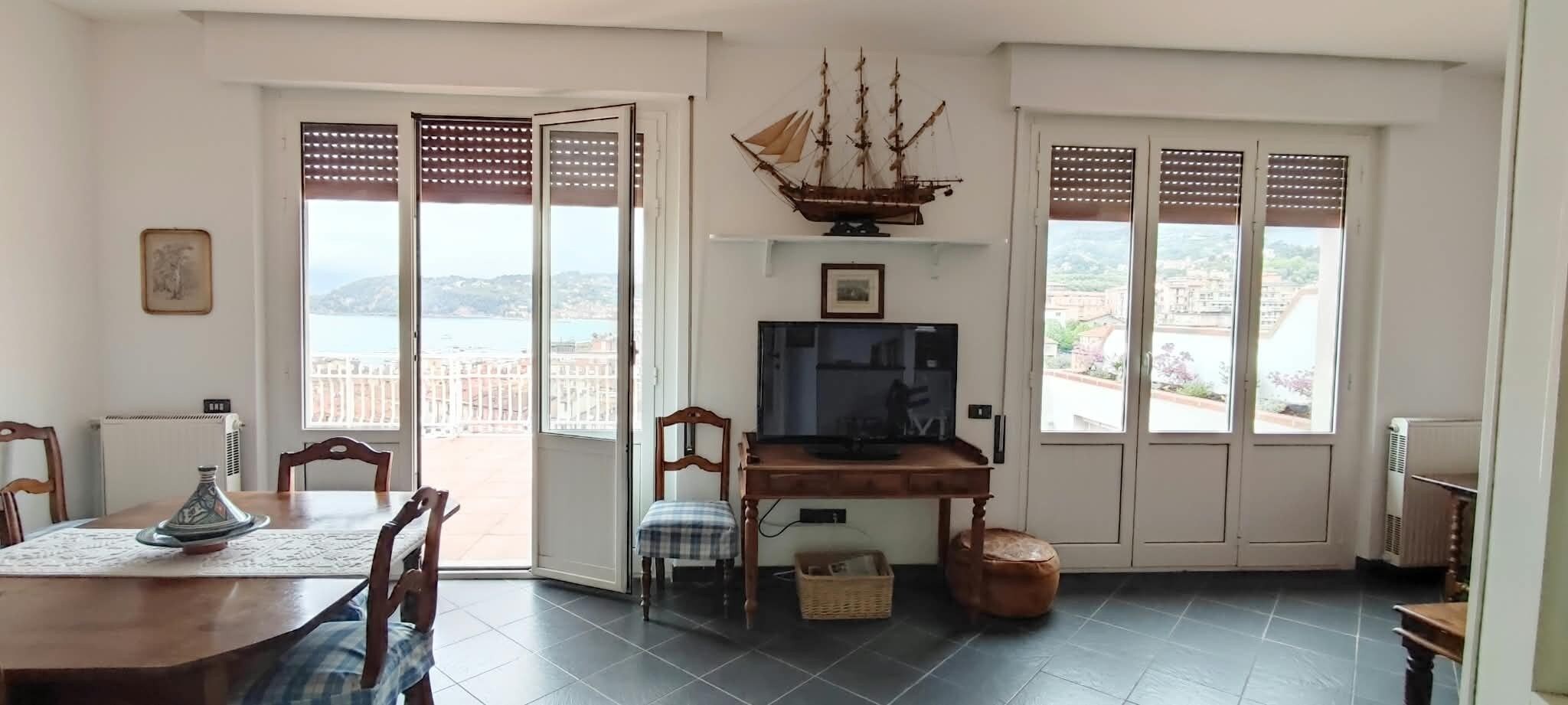 Zona pranzo con tavolo, sedie e televisore.