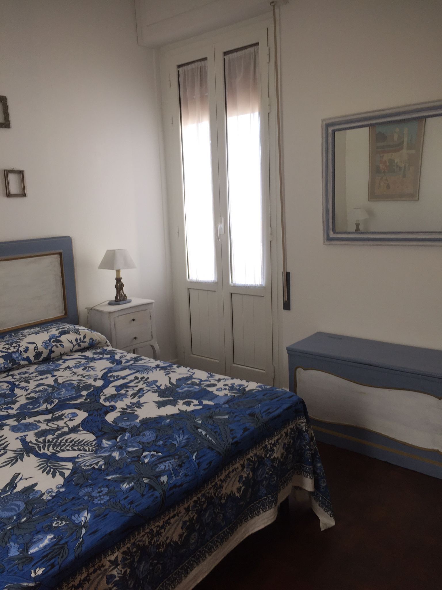 Una camera da letto con un letto, un comodino, una lampada e una scrivania.