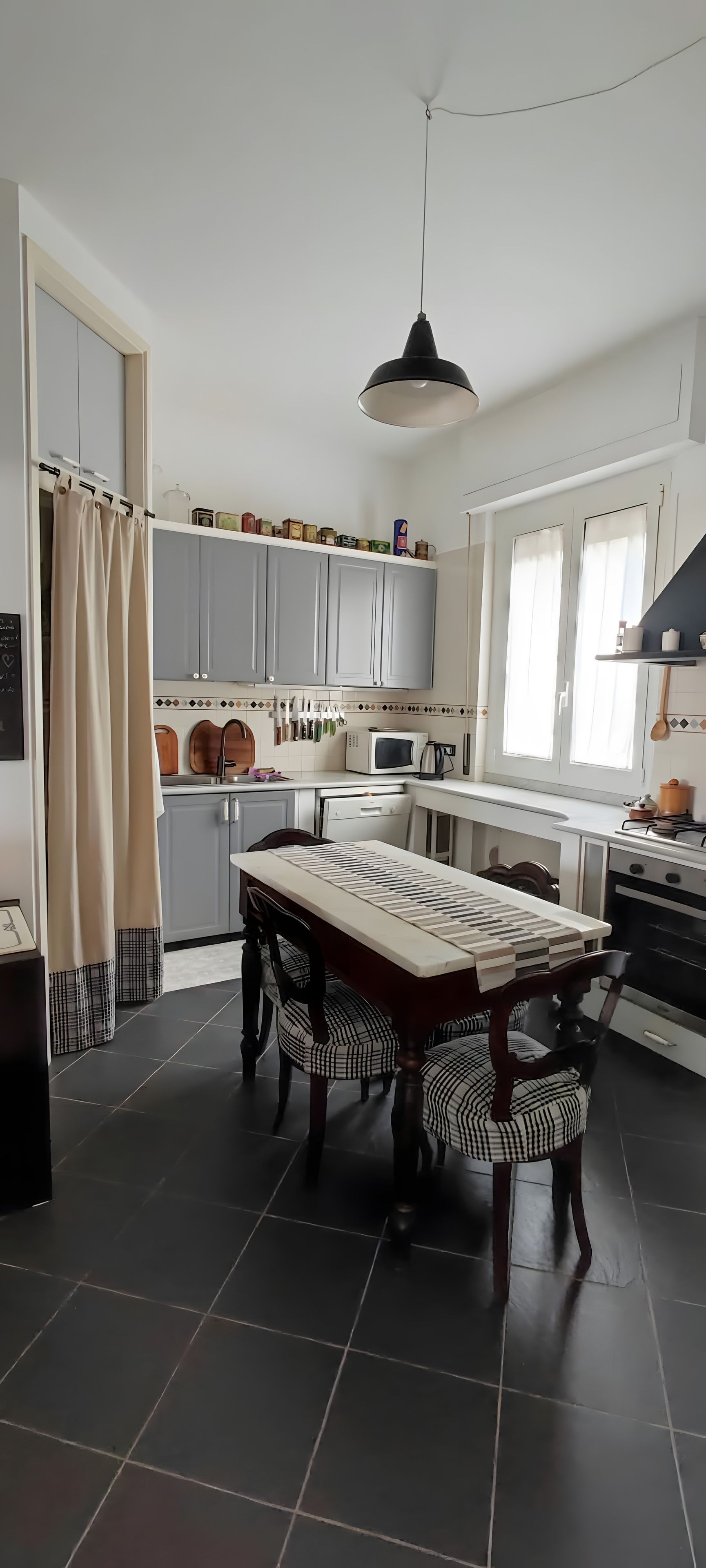 Una cucina moderna con isola centrale, pensili e zona pranzo con sedie.