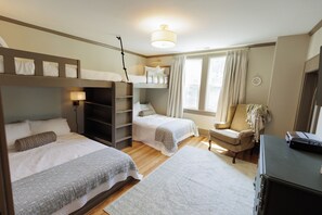 A bedroom with bunk beds, a desk, a chair, and a window with curtains. -  Spacious 4-Bedroom Group and Family Retreat: Game Room, Bunk Room, Walk2Shops (Matthews)