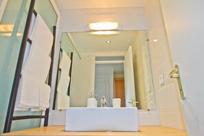 A modern bathroom with a white sink, a glass shower enclosure, and a visible towel rack. - Duplex Papaye Deshaies. Sea view. Swimming pool (Deshaies)