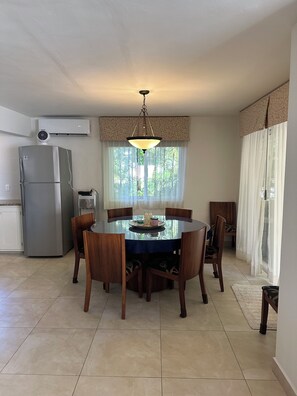 A dining area with a round table, chairs, and a chandelier. - Stunning 4 bedroom Villa Best Location in Playacar (Playa del Carmen)