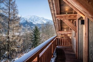 A wooden balcony with a view of snow-covered mountains. - Luxury Mountain Chalet with Jacuzzi, Sauna & Hammam near Mont Blanc (Saint-Gervais-les-Bains)