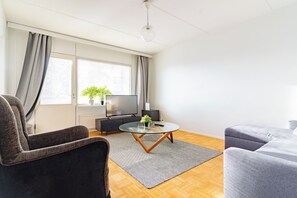 Una sala de estar moderna con un sofá, una mesa de centro y un televisor.