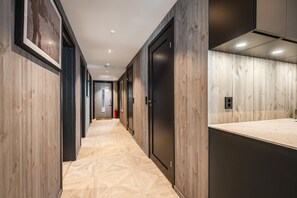 A hallway with wooden paneling, a patterned floor, and a door with a handle. - Alpelia Ski-in Ski-out apartment in Hemsedal (Hemsedal)