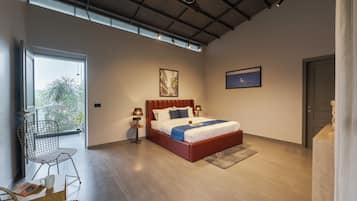 A modern bedroom with a large bed, a desk, and a chair.