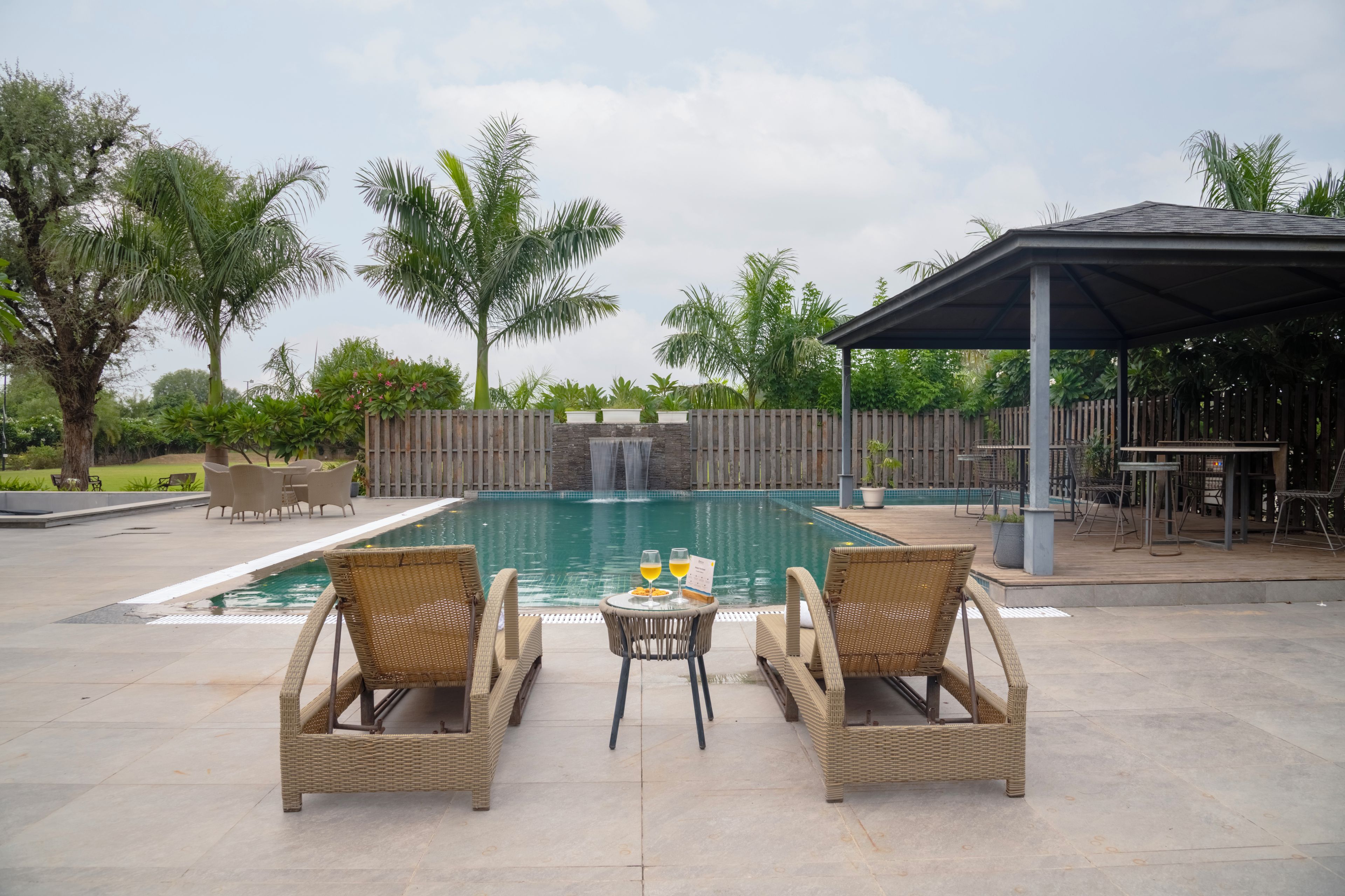 A poolside area with wicker furniture and a covered seating area.