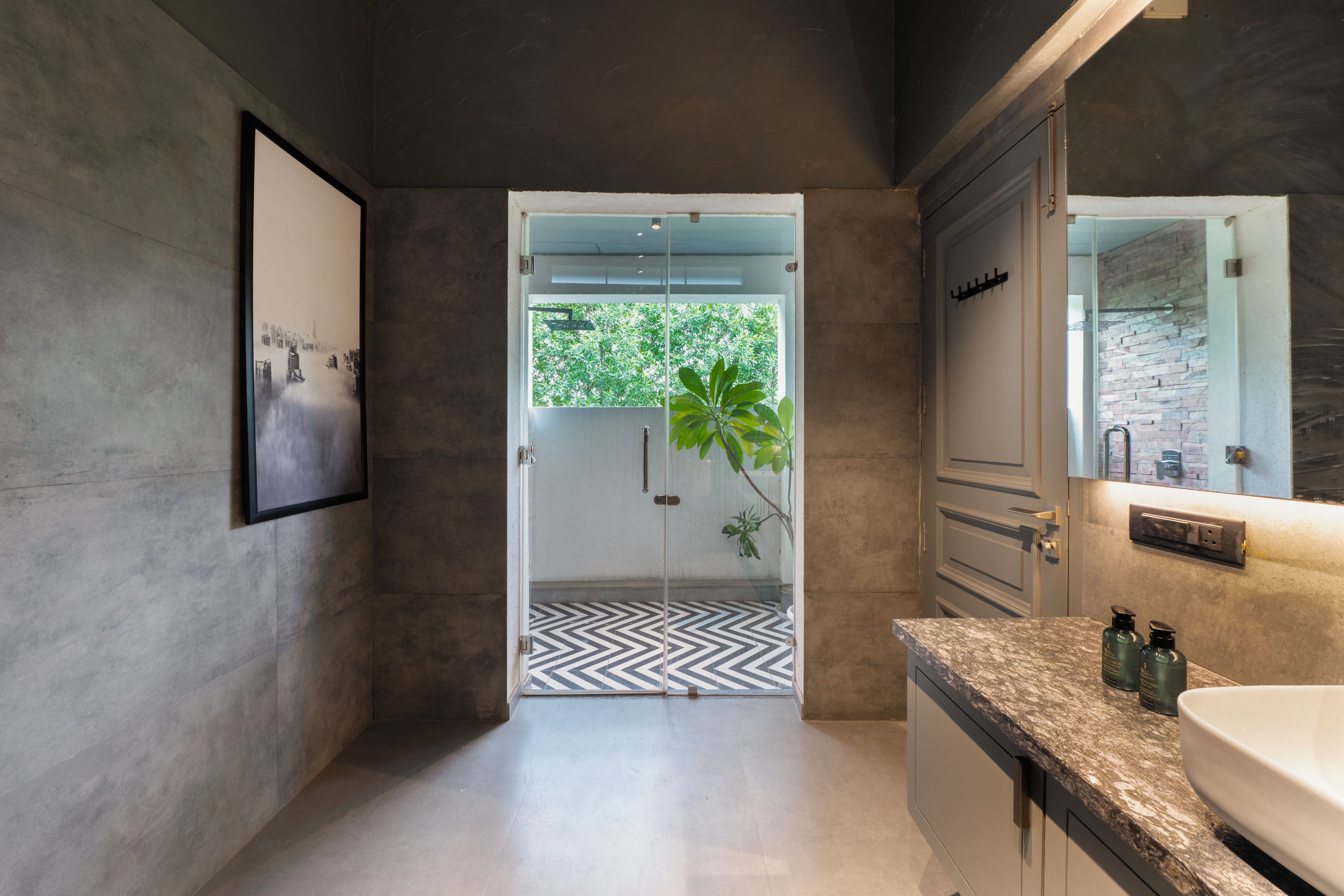 A modern bathroom with a large mirror, a sink, and a shower area.