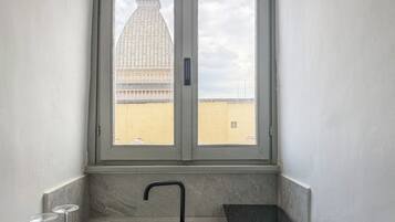 A bathroom with a window, a sink, and two glasses.