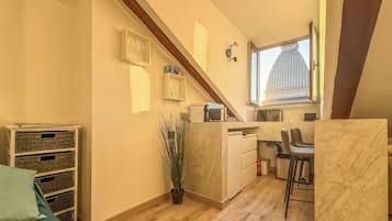 Una cocina compacta con ventana, una planta en maceta y un pequeño comedor.