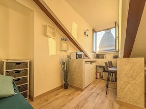 A compact kitchen with a window, a potted plant, and a small dining area. - Mole House (Torino)