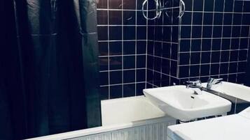 Une salle de bain équipée de toilettes, d’un bidet et d’un lavabo.