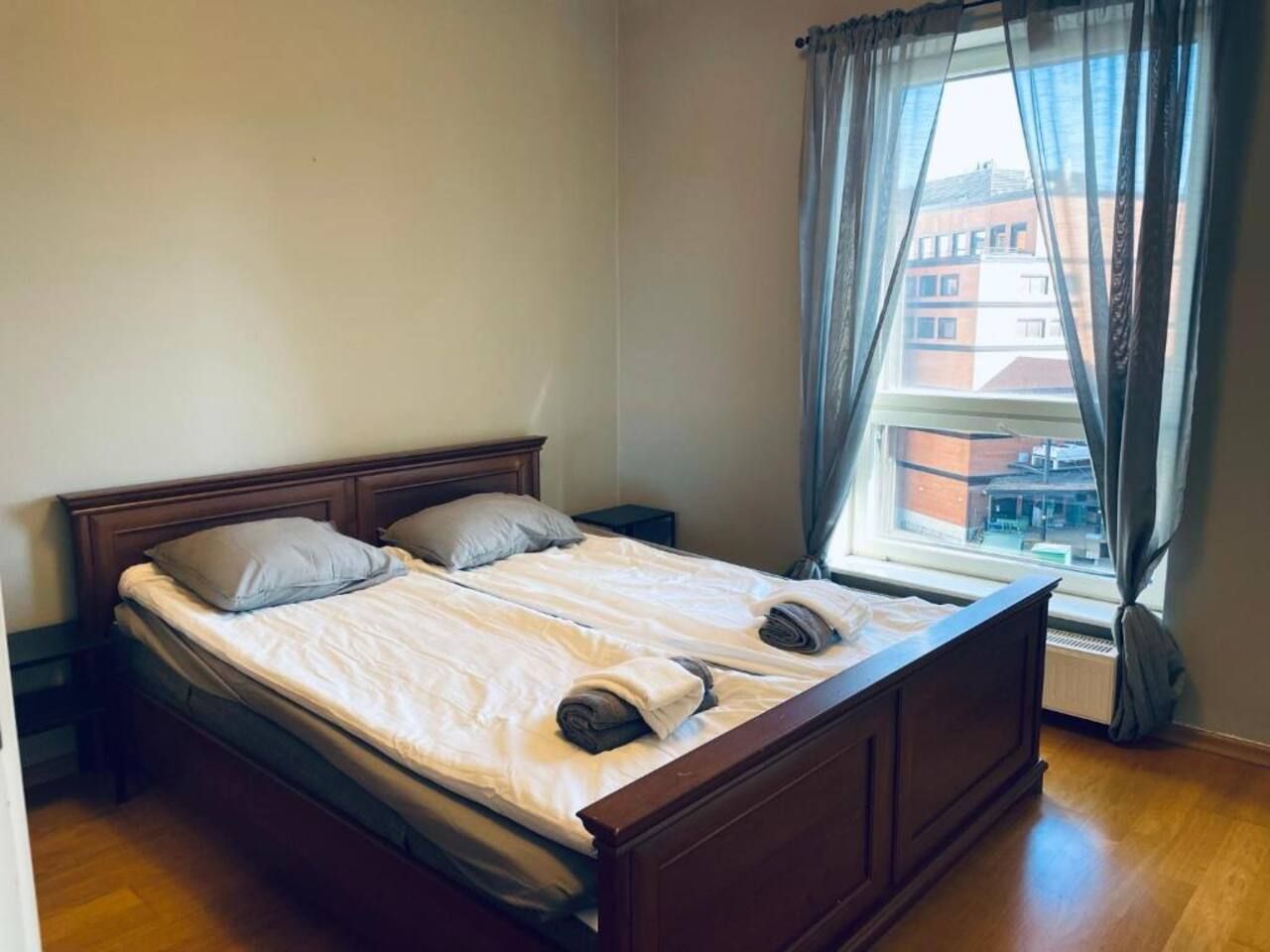 A double bed with a wooden frame, two pillows, and a blanket.